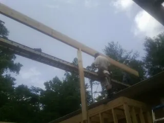 Carpenter setting a ridge beam over a new addition frame — Ice Dam Removal by Roofing Brothers in South Orange