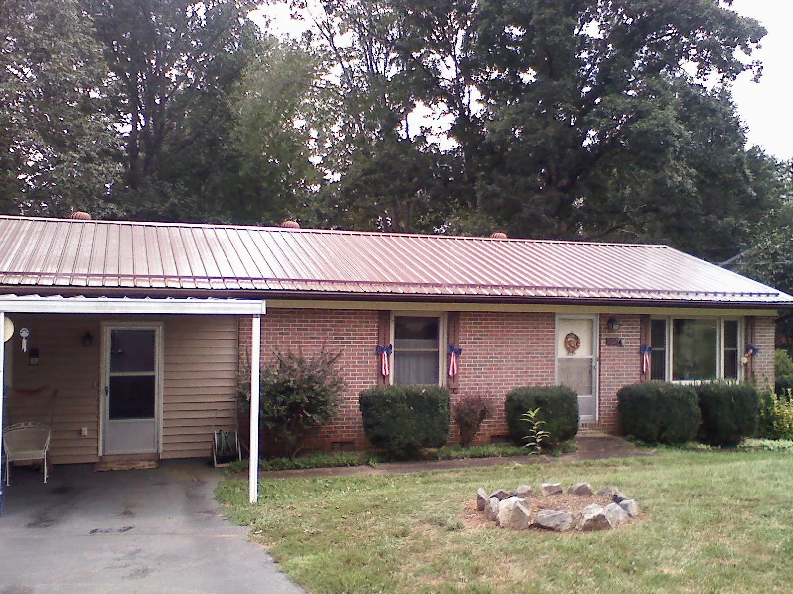 Bronze metal roof and carport on a brick ranch home — Roof Repair work by our crew in South Orange