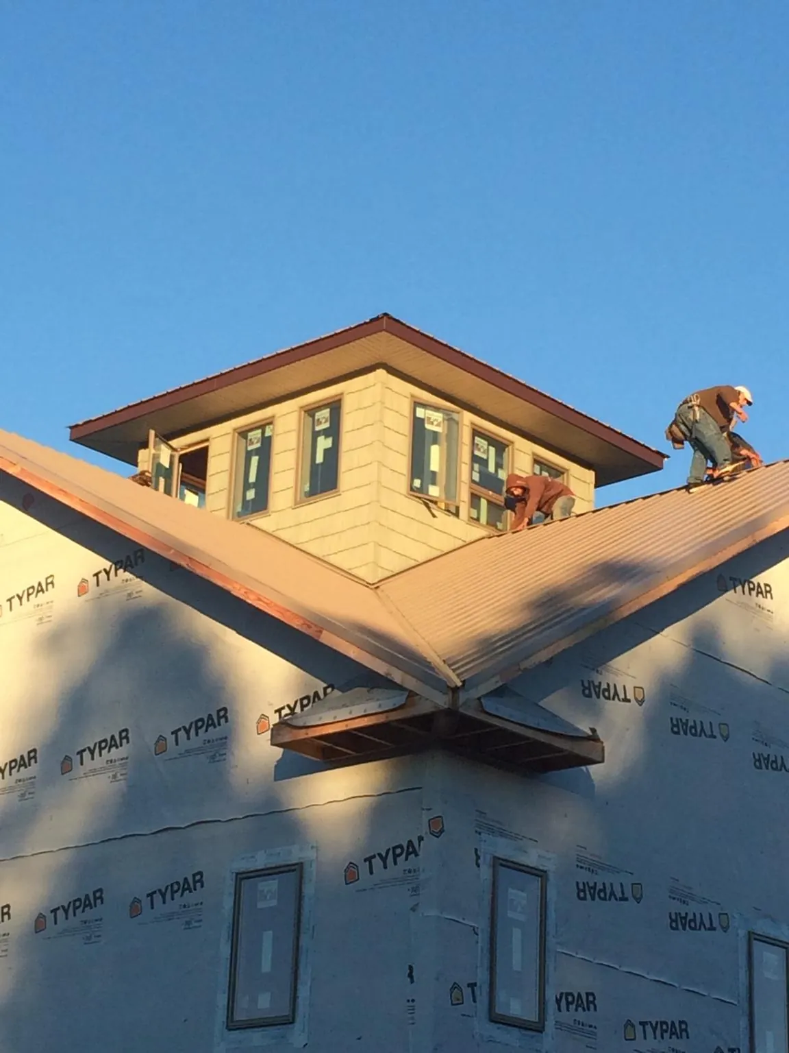 Roofers working around a rooftop cupola on a new metal roof at sunset — Roof Waterproofing in South Orange by Roofing Brothers